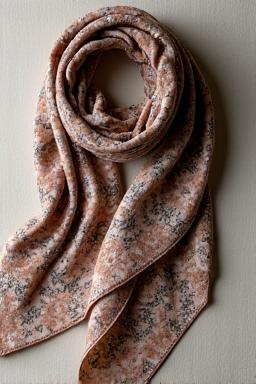 Luxurious silk scarf with an intricate floral and geometric pattern in muted tones.